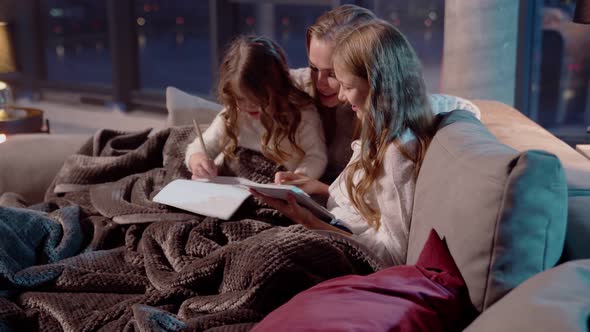 Two Sisters Resting with Beautiful Mother on Couch