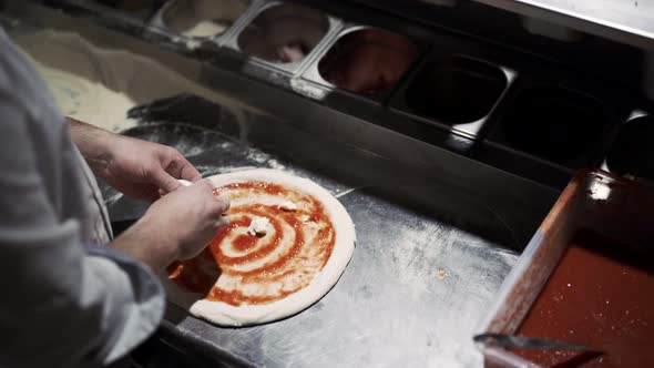 Male Chef Hands Making Pizza in the Pizzeria Kitchen