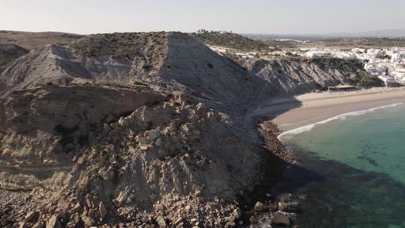 Aerial view of Praia de Burgau Blue Flag beach and cliffs, Burgau, Portugal, wide shot