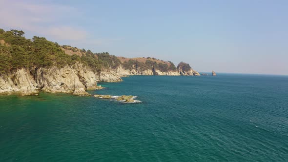 Aerial View of the Rocky Seashore of a Beautiful Bay with Transparent Water