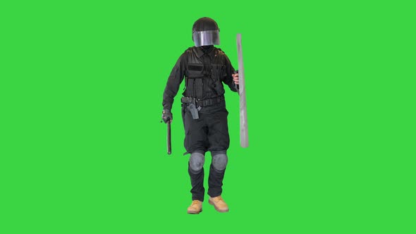 Riot Policeman with a Shield and Baton Walking on a Green Screen Chroma Key