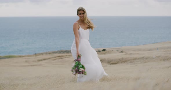 A beautiful bride walking through golden fields