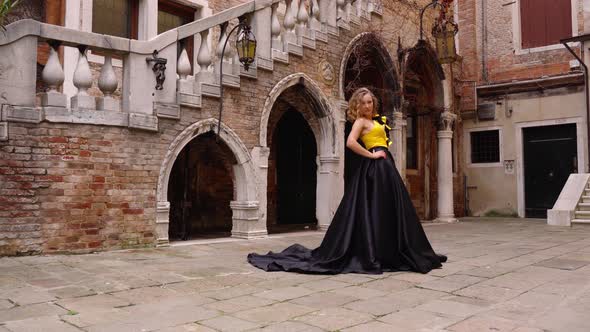 Lady in Evening Dress Holds Hand on Hip and Poses for Camera