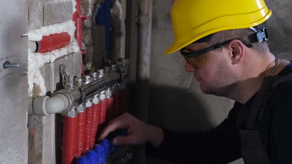 A Male Plumber Sets Up Heating in a Newly Built House