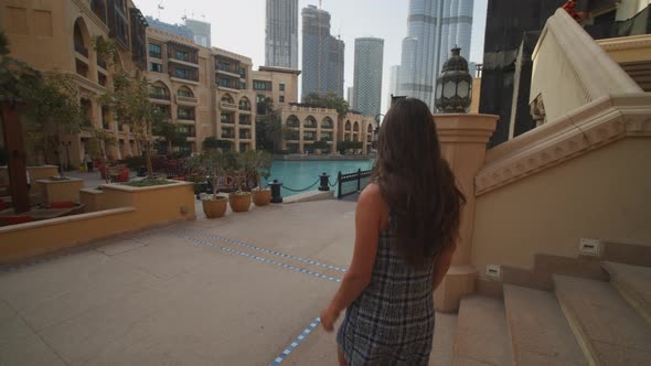 Following a Woman Walking in Urban City Center of Dubai with Burj Khalifa Skyscraper