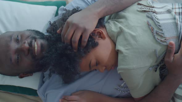 Loving Dad Lying with Sleeping Son on Bed