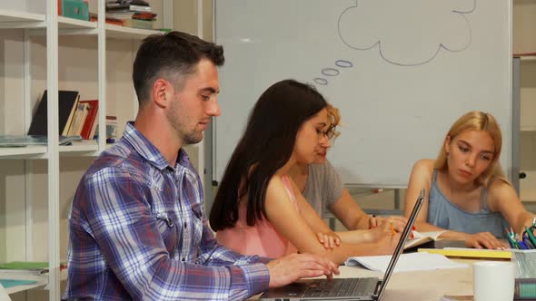 Handsome Male Student Showing Thumbs Up While Using Laptop