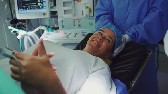 Close--up of Caucasian man comforting pregnant woman during labor in operation theater 