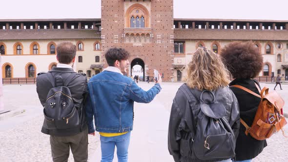 Group of four multiethnic traveller friends smiling happy walking