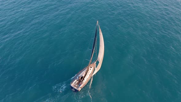 Aerial View. Yacht in Amazing Clear Sea. Sailboat View From Drone.