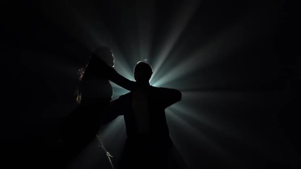 Young Couple Dancing Latin Music. Bachata, Merengue, Salsa. Shot in a Dark Studio with Neon Lights