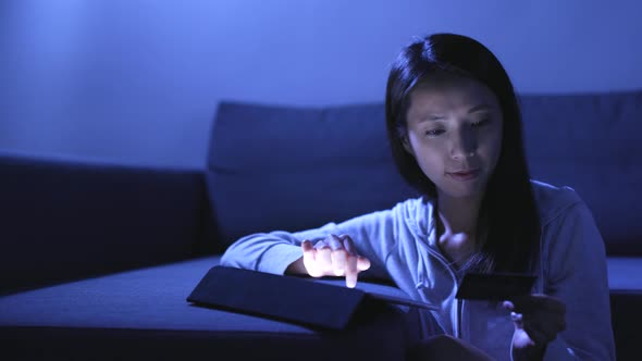 Woman using tablet computer at night 