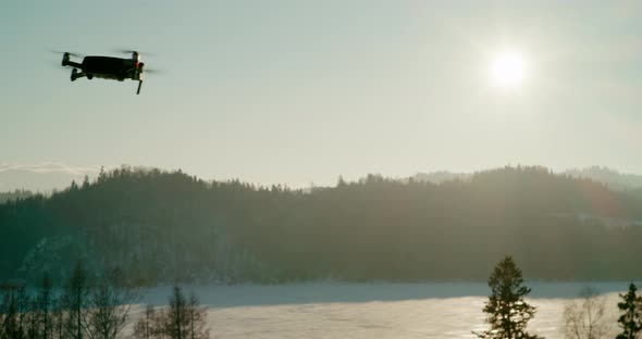 UAV Drone Flying From Left to Right Over Mountains at Sunset