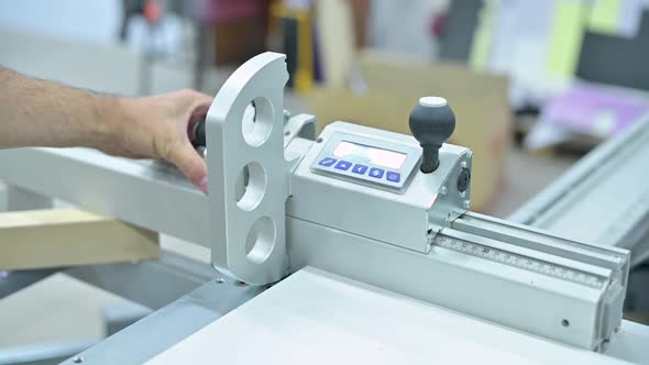 The man sets up the marking on the electronic board of the circular saw