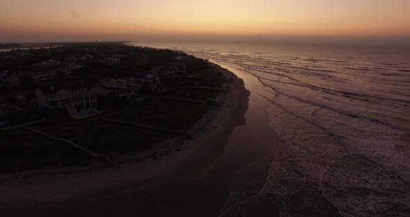Aerial of ocean waves on island beach at sunrise