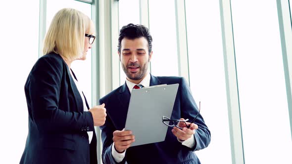 Two Business People Talk Project Strategy at Office