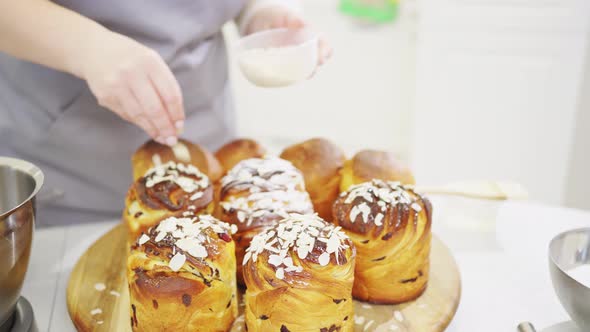 a Female Cook Sprinkles with Powdered Sugar and Almonds a Kraffin Easter Cake