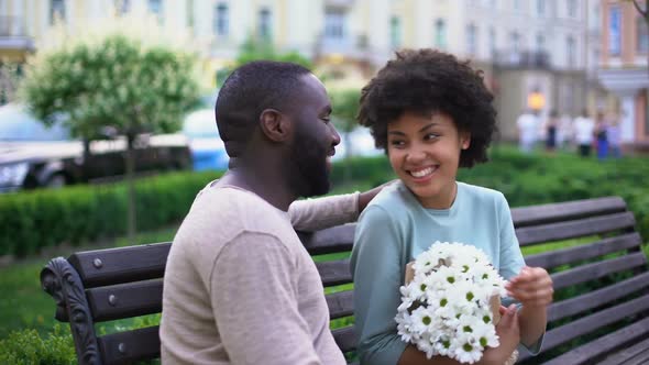 Afro-American Loving Couple Nuzzling on Bench, Enjoying Summer Day Together