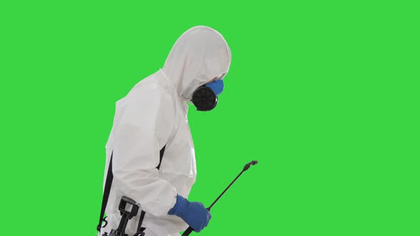 Worker in Hazmat Suit and Face Protection Mask Walking With Disinfection Equipment on a Green Screen