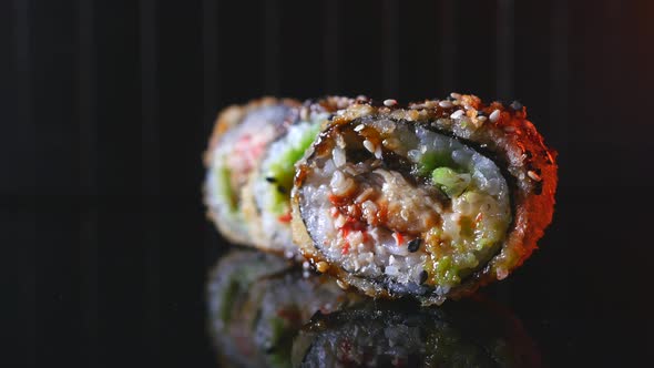 Closeup of Delicious Tempura Rolls with Eel Taking with Chopsticks