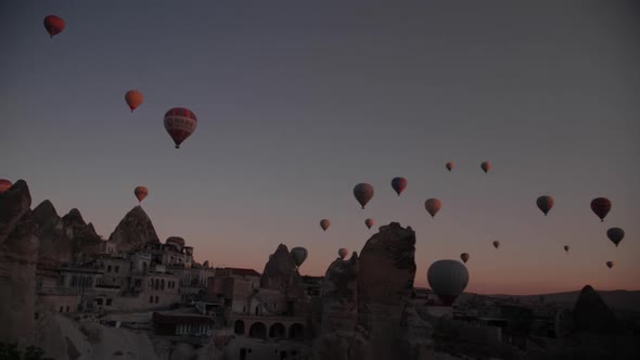 Hot air balloons seen from a cave hotel in Goreme, Cappadocia, at sunrise