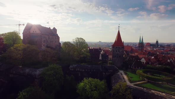 Aerial city with a castle in the foreground at beautiful sunrise with sun flares