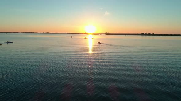 Aerial Drone Footage. A Group of Tourists Are Kayaking. Beautiful Sunrise Over River