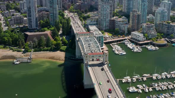 Traffic Driving At Four-lane Burrard Bridge With Moored Boats In Marina By False Creek - Reveal Shot