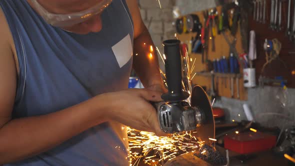 Professional Repairman or Mechanic Worker Sawing Metal with a Circular Saw in Garage