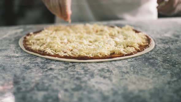 Close Up for Cook's Hands Putting Cheese on the Pizza Four Cheeses