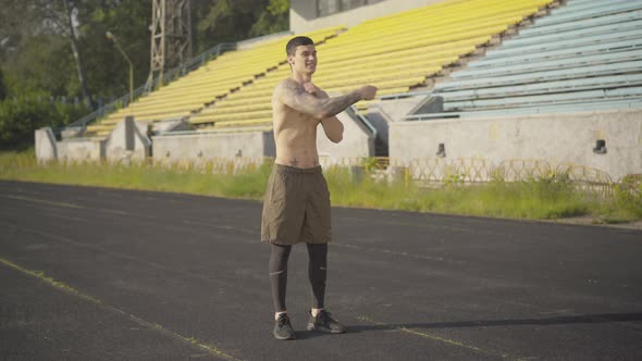 Wide Shot of Cheerful Sportsman Using Jumping Rope for Training Outdoors. Portrait of Happy Young