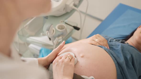 Doctor Monitoring Baby Heartbeat of Pregnant Woman