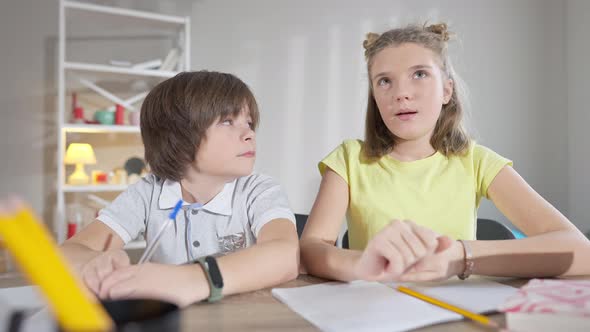 Confident Caucasian Schoolgirl Raising Hand and Answering Question As Schoolboy Admiring Classmate