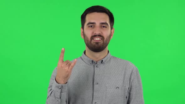 Portrait of Brunette Guy Is Making a Rock Gesture and Enjoying Life. Green Screen