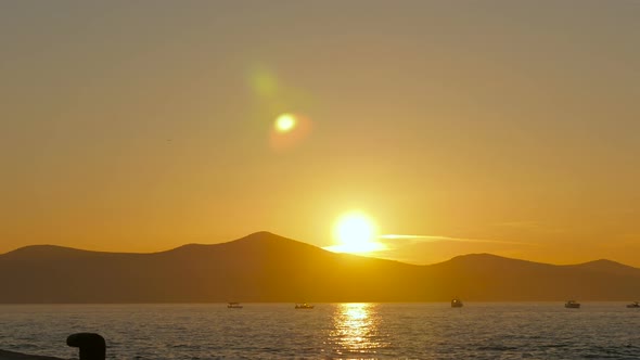 Sunset over hills and boats