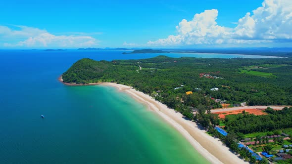 Aerial top view over city and sandy beach. coconut trees.