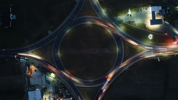 Aerial View of Road Roundabout Intersection with Fast Moving Heavy Traffic at Night