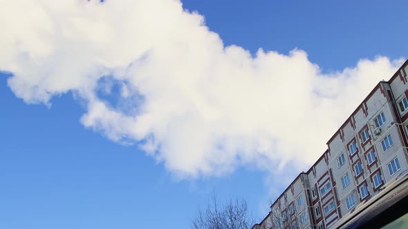 Thick White Smoke Like Steam or a Cloud Moves Over the Roof of a House