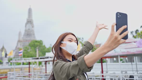 Asian woman backpacker use mobile phone selfie, take picture in city.