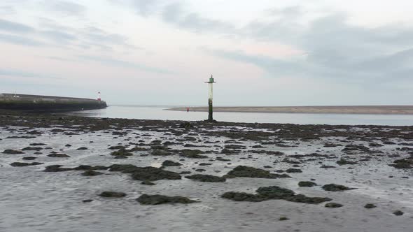 A Channel Marker at Low Tide in an Estuary