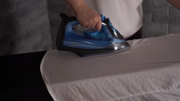 Woman Ironing Clothes on Ironing Board Closeup