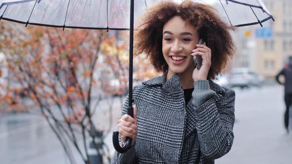 Happy Active Friendly Curly Haired Girl African American Woman with Transparent Umbrella in City in