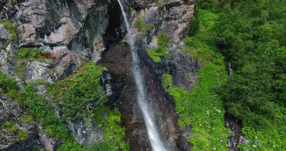 Waterfall in the Mountains in the Middle of a Green Forest