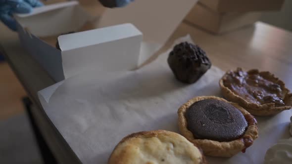 Homemade Pastry Delivery. Cake Shop Business. Woman Putting Cupcakes in Box.