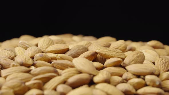 A Handful of Dried Almond Rotate on a Black Background