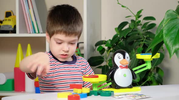 A Preschool Boy Learns Numbers Weighs Numbers on a Penguin Scale