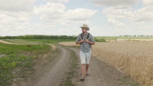 Thoughtful Man Walk Hiking Along Rural Road in Field Plains. Male Tourist Travel Adventurer Wanderer