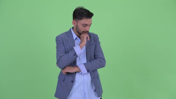 Stressed Young Bearded Persian Businessman Thinking and Looking Down