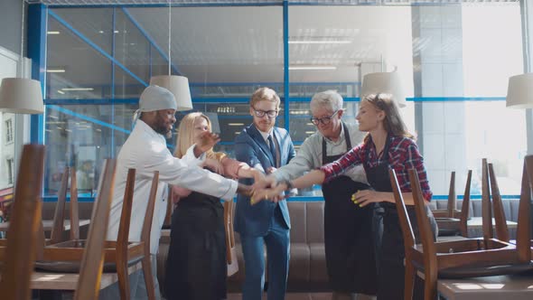 Team Of Happy Diverse Cafe Staff Joining Hands Together Celebrating Successful Startup