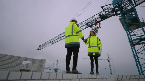 Foreman and Civil Engineer are Discussing Construction Project in Building Site Man and Woman are